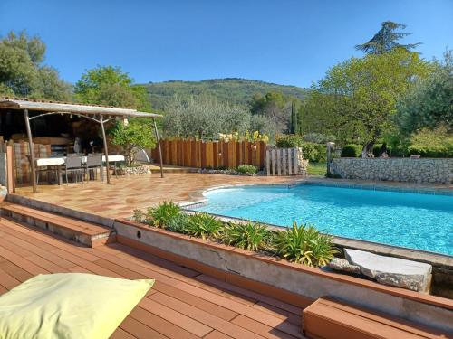 une cour arrière avec une piscine et une terrasse en bois dans l'établissement Lou Viei Jas, à Figanières