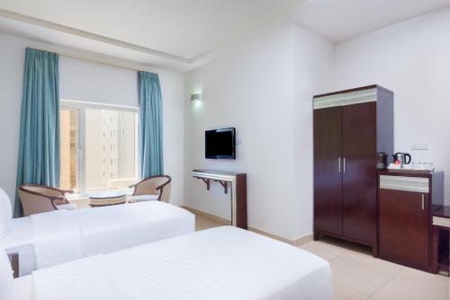 Postel nebo postele na pokoji v ubytování Centara Life Muscat Dunes Hotel