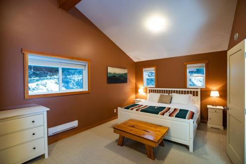 ein Schlafzimmer mit einem Bett und einem Tisch darin in der Unterkunft Stoke Cabin by Revelstoke Vacations in Revelstoke