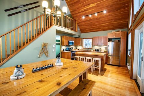 a kitchen with a wooden table and a staircase at Stoke Cabin by Revelstoke Vacations in Revelstoke