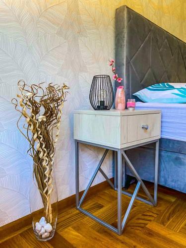 a bed room with a table and a vase with a plant at Apartman Barocco in Trebinje