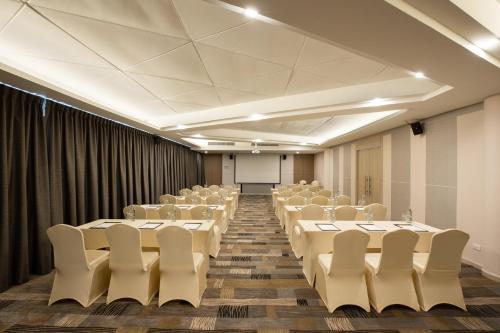 a room with rows of tables and white chairs at Centara Life Cha-Am Beach Resort Hua Hin in Cha Am