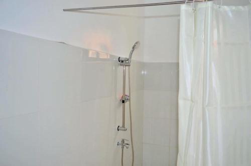 La salle de bains est pourvue d'une douche avec rideau de douche. dans l'établissement Cozy Vacation House in Guimaras, à Guimaras