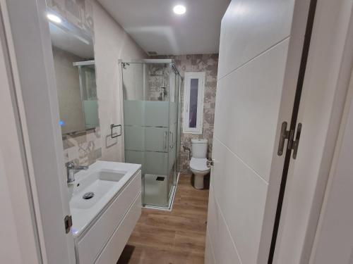 a white bathroom with a sink and a toilet at Alojamiento Paco Cabrera in Almuñécar