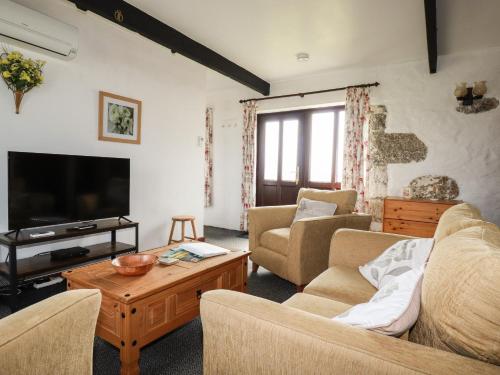 a living room with a couch and a tv at Kestrel Corner in Lanivet