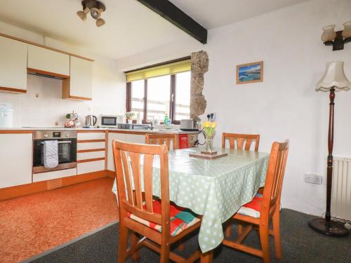 a kitchen and dining room with a table and chairs at Kestrel Corner in Lanivet