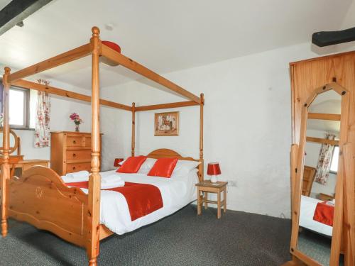 a bedroom with a four poster bed and a mirror at Kestrel Corner in Lanivet