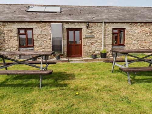 a couple of picnic tables in front of a building at Ravens Croft in Lanivet