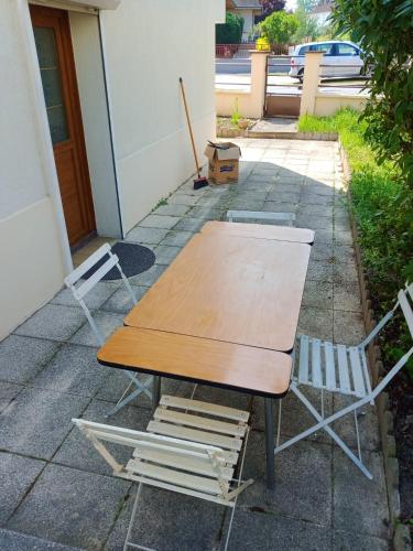 une table et deux chaises assises à côté d'un bâtiment dans l'établissement Maison confortable à Montluçon avec Jardin clôturé, à Montluçon