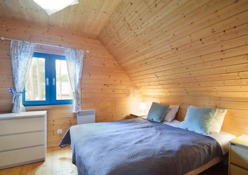 ein Schlafzimmer mit einem Bett in einer Holzhütte in der Unterkunft Kolorowe Domki in Pobierowo