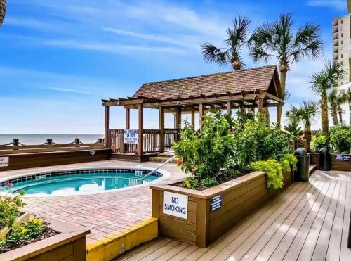 a swimming pool with a gazebo next to the beach at 1109 Waters Edge Resort condo in Myrtle Beach