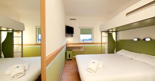 a hotel room with two beds with towels at ibis Budget Manchester Centre Pollard Street in Manchester