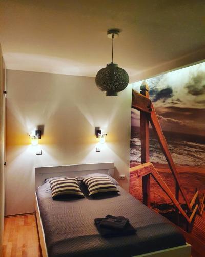 a bedroom with a bed with a painting on the wall at Alo Alo Apartman 6 in Kruševac