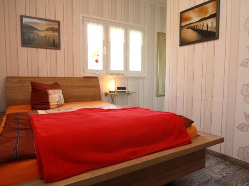 um quarto com uma cama com um cobertor vermelho em holiday home, Berlin em Berlim