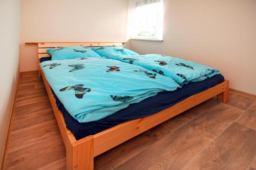 a bed with a blue comforter with fish on it at Bungalow Am Spreeufer Lübben - DBS05100b-B in Lübben