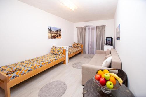 a living room with two beds and a couch at Apartment Studio Premier in Rafailovici