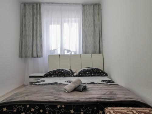 a bedroom with a bed with a large window at Casa Fery in Băile Herculane