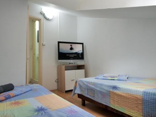 a bedroom with two beds and a flat screen tv at Casa Fery in Băile Herculane