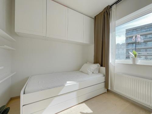 a white bedroom with a bed and a window at CITY CENTER Penthouse apartment in Oslo