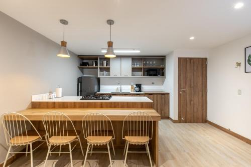 a kitchen with a wooden counter and four chairs at Villaz Luxury Vacation Homes in Medellín