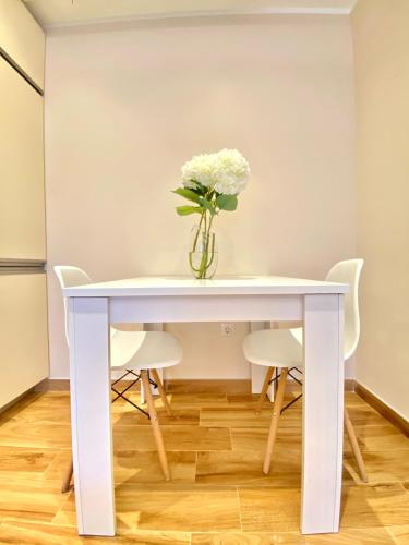 a white table with a vase of flowers on it at Villa Blanca in Risan