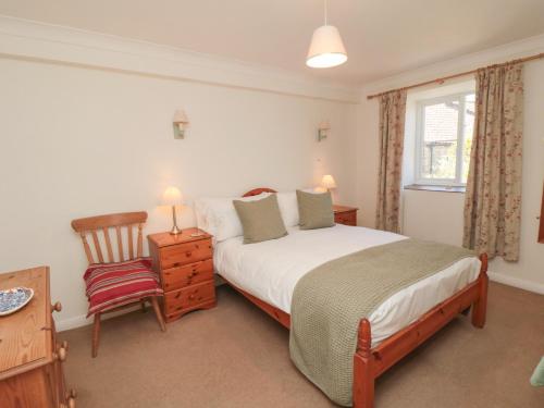 um quarto com uma cama grande e uma cadeira em Westgate Cottage em Pickering