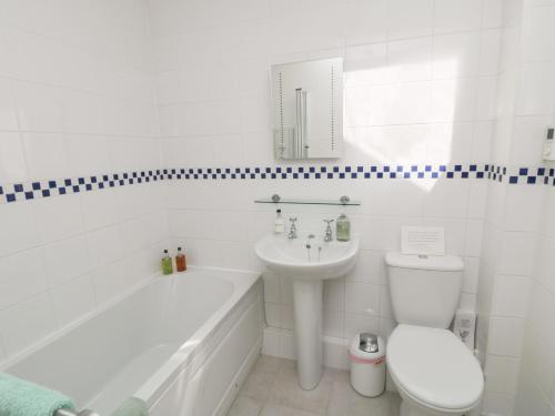 a white bathroom with a toilet and a sink at Westgate Cottage in Pickering