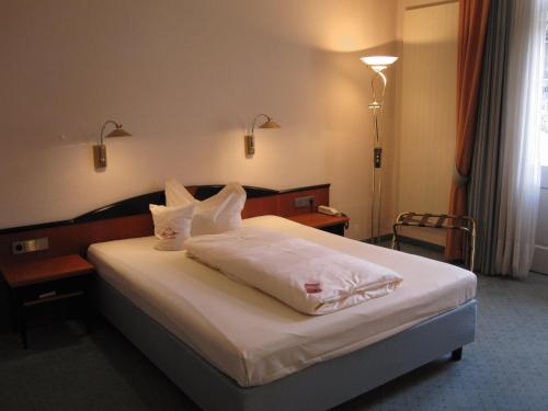 a bedroom with a bed with white sheets and pillows at Sax Imperial in Dresden