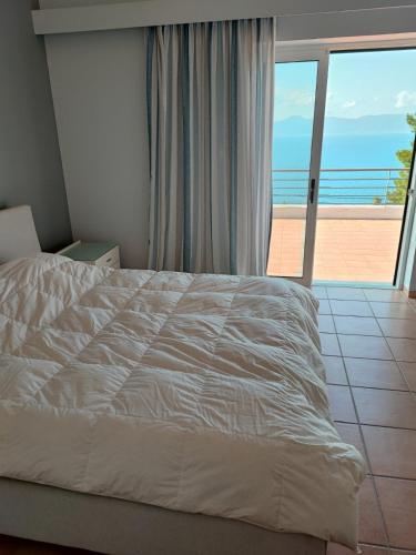 a bedroom with a bed and a view of the ocean at VILA AMALIA in Theologos