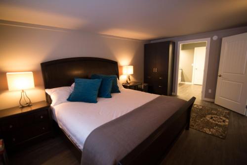 a bedroom with a large bed with blue pillows at Clipperton Suite by Revelstoke Vacations in Revelstoke