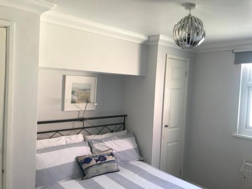 a bedroom with a bed and a chandelier at Kiki’s Corner in Newquay