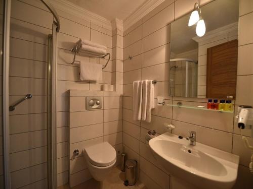 a bathroom with a sink and a toilet and a mirror at Nicholas Park Hotel in Fethiye