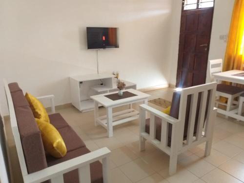 a living room with a couch and a table at Hyven's Apartments in Mtwapa