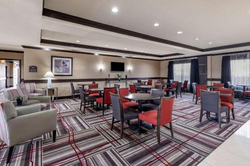 a hotel lobby with a waiting room with tables and chairs at Best Western Plus DFW Airport West Euless in Euless