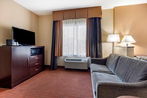 a living room with a couch and a television at Best Western Plus DFW Airport West Euless in Euless