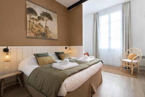 - une chambre avec un grand lit et des serviettes dans l'établissement NATICE Bel appartement dans résidence privée, à Saint-Martin-de-Ré