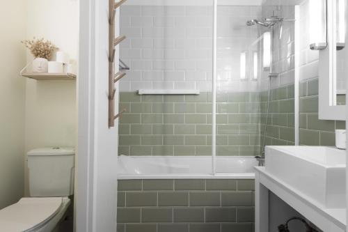 a bathroom with a tub and a sink and a toilet at NATICE Bel appartement dans résidence privée in Saint-Martin-de-Ré