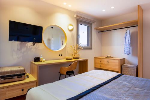 a bedroom with a bed and a desk and a mirror at Searenity Villa Malia with private swimming pool in Malia