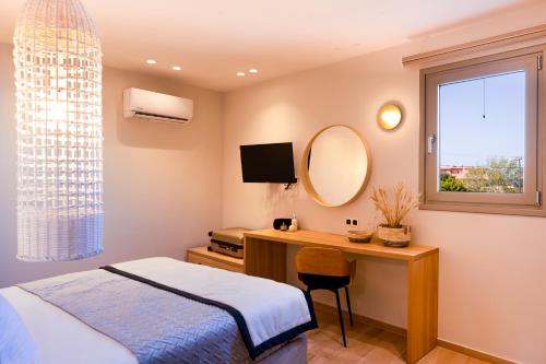 a bedroom with a bed and a desk with a mirror at Searenity Villa Malia with private swimming pool in Malia