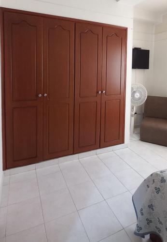 a living room with brown cabinets and a couch at San Juan Del Lago in Pereira