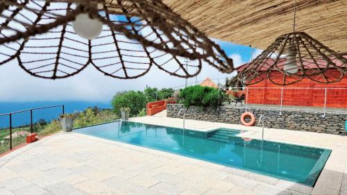a villa with a swimming pool and a building at Madeira Sunset Cottage - Nature Retreat in Ponta do Pargo