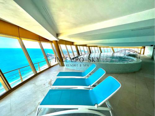 a group of chairs in a room with the ocean at INTEMPO SKY Resort & Spa in Benidorm