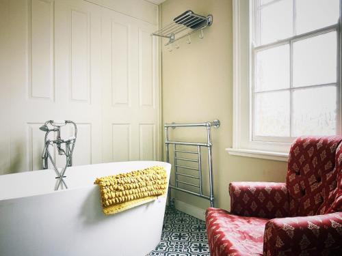 een woonkamer met een bank en een stoel bij Manor House of Cheshunt- Historic Villa in Cheshunt