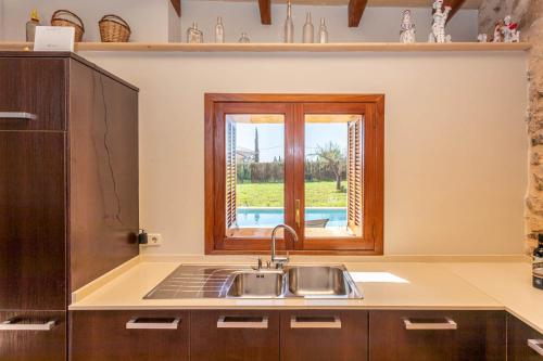 eine Küche mit Spüle und Fenster in der Unterkunft Ca n Batlet in Inca