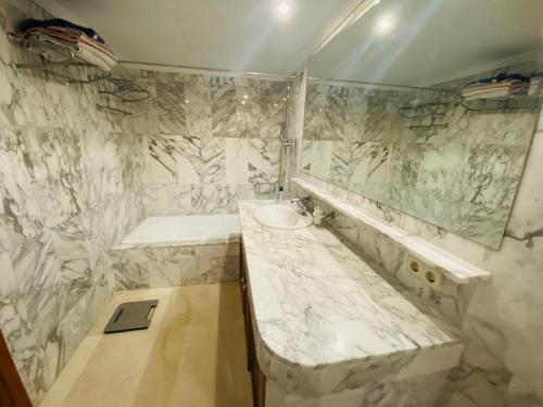 a marble bathroom with a sink and a tub at Fantastic Anfi Tauro Duplex with ocean view in Las Palmas de Gran Canaria