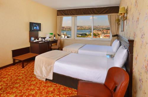 イスタンブールにあるPera Rose Hotelの大きなベッドと窓が備わるホテルルームです。