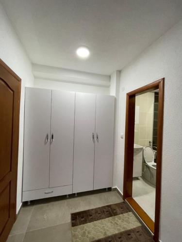 a bathroom with white cabinets and a mirror at Hotel5E in Plav