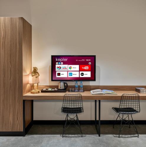 a desk with a monitor and two chairs on it at Kepler Club Sabiha Gökçen Airport - International Transit Area in Istanbul