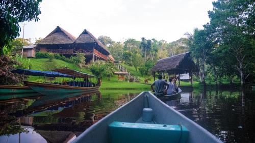 a couple of people in a boat on a river at Yarina Eco Lodge in Derna