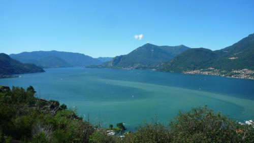a helicopter flies over a large lake with mountains at Il girasole in Dervio